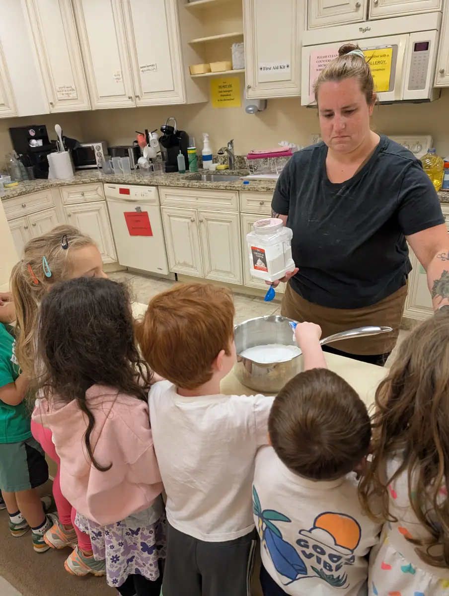 Children measuring and mixing ingredients during a hands-on cooking activity at Blossom Station in Acton, MA
