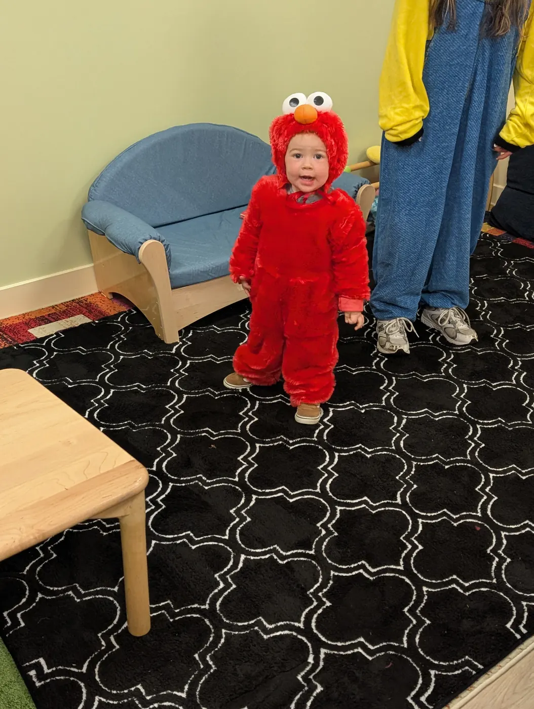 A toddler dressed as Elmo in a Blossom Station classroom on Halloween 2026