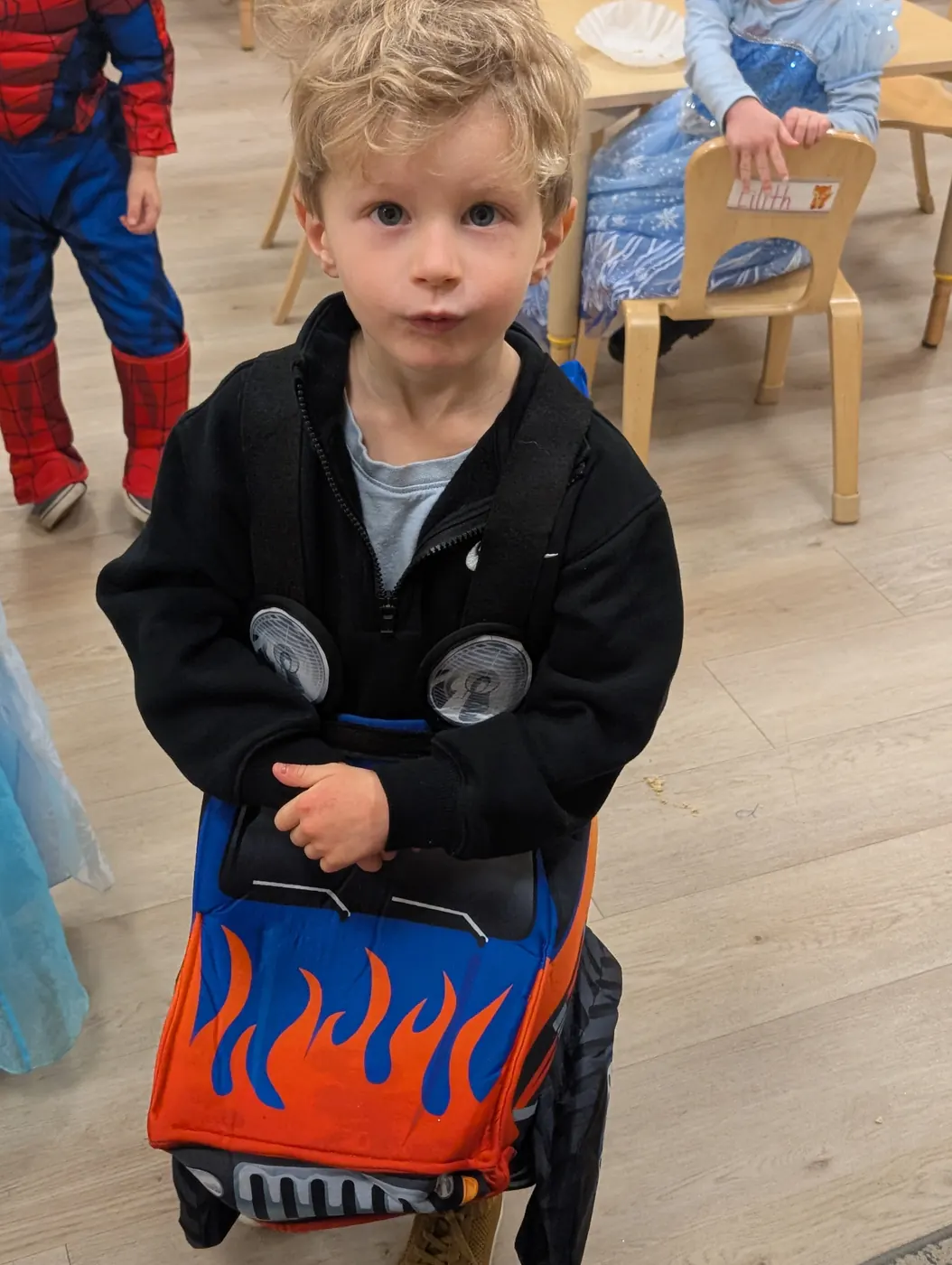 A preschooler dressed as a monster truck driver at Blossom Station's Halloween Parade