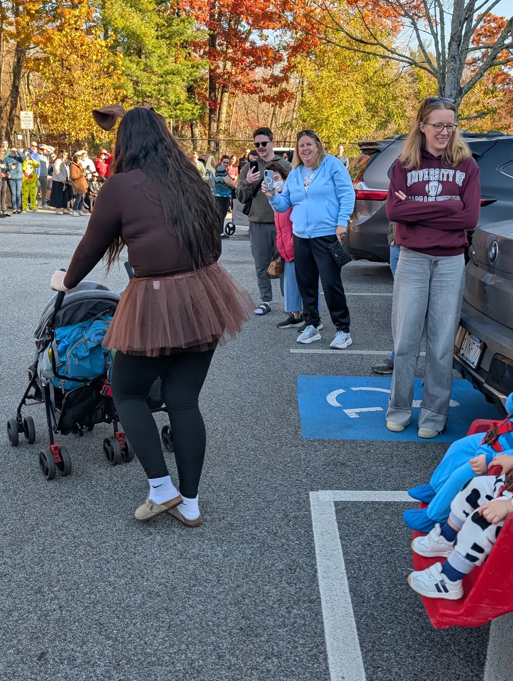 Grown-ups and little ones in costume making their way along the Halloween Parade route