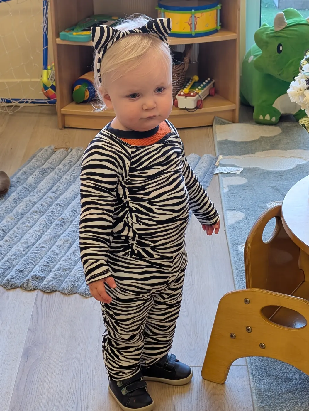 A toddler in a zebra costume and ears in a Blossom Station classroom on Halloween