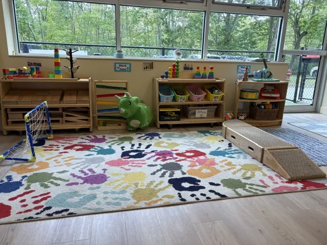 A bright Blossom Station classroom with a colorful handprint rug